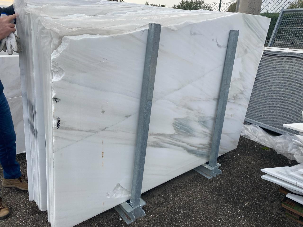 Natural stone slabs in a rack being checked manually